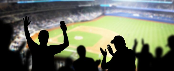 A silhouette of fans cheering at a baseball game