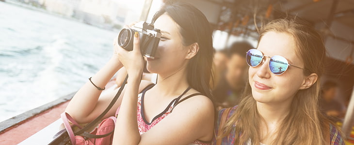 Two tourists take photos on a boat tour