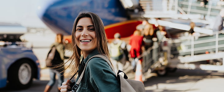 A tourist boards an airplane and smiles