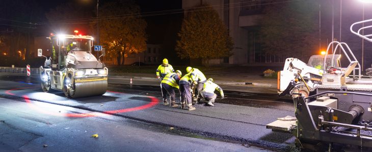 a construction crew working on a road project at night after dark