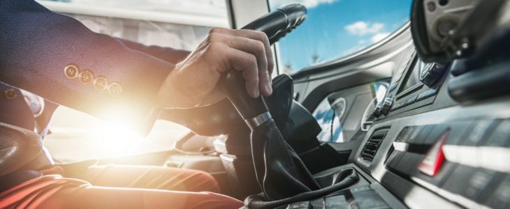 a bus driver at the wheel of a shuttle bus