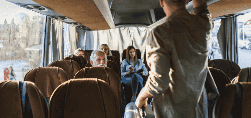 a woman sits in a charter bus seat and smiles