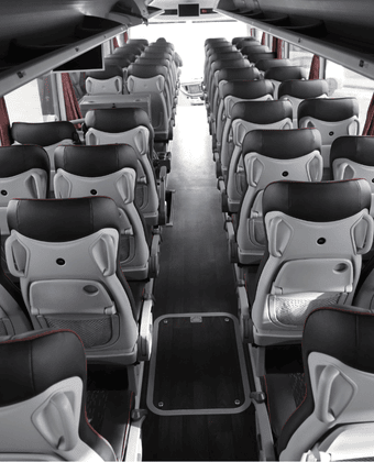 Interior of a bus rental with a passenger sitting in a seat facing away