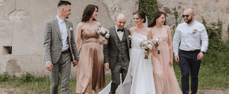 a bride and groom walk with guests at a wedding