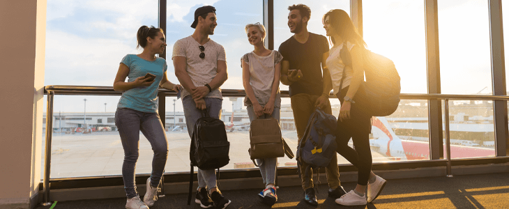 a group of people waiting at the airport with luggage